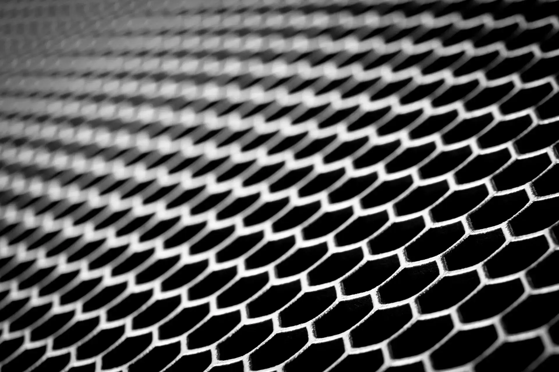Close-up of hexagonal metal mesh pattern, geometric grid representing structured design and product creation